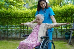 il medico aiuta il paziente asiatico della disabilità della donna anziana nell'ospedale di cura, concetto medico. foto