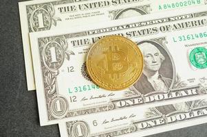 bitcoin dorato su banconote in dollari statunitensi soldi per affari e commerciali, valuta digitale, criptovaluta virtuale, tecnologia blockchain. foto