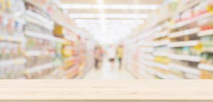 piano del tavolo in legno con sfondo sfocato corridoio del supermercato per la visualizzazione del prodotto foto