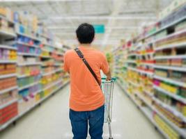 giovane uomo shopping nel supermercato foto