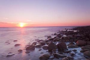 sole al tramonto sulla costa svedese foto