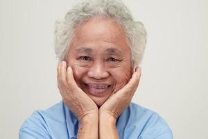 donna anziana asiatica paziente seduta e faccia sorridente con felice sul letto in ospedale. foto