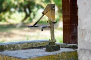 vecchia pompa dell'acqua manuale in piedi sul ciglio della strada nel foto