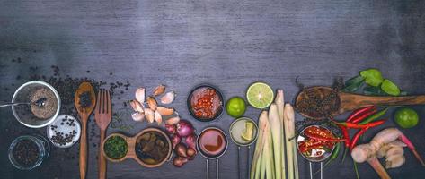 spezie da utilizzare come ingredienti da cucina su un fondo di legno con verdure fresche. erbe e spezie alimentari sane. verdure biologiche in tavola. foto