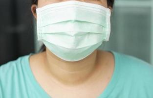 primo piano la donna che indossa una maschera facciale previene germi e virus, protegge l'epidemia di inquinamento atmosferico da polvere in città. foto