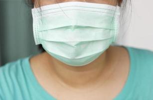 primo piano la donna che indossa una maschera facciale previene germi e virus, protegge l'epidemia di inquinamento atmosferico da polvere in città. foto