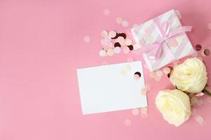 scatole regalo e fiori di rosa su sfondo rosa. buon san valentino, festa della mamma, concetto di compleanno. composizione romantica piatta. foto