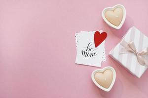 buona composizione di san valentino. mockup di biglietto di auguri vuoto, scatole regalo, cuori rossi, coriandoli su sfondo rosa foto