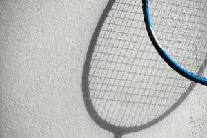 l'ombra delle racchette da badminton sul muro bianco, messa a fuoco morbida e selettiva, concetto per gli amanti dello sport di badminton in tutto il mondo. foto