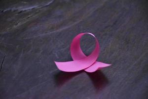 nastro rosa su tavola di legno, concetto per combattere il cancro al seno nelle donne di tutto il mondo. messa a fuoco selettiva e spazio di copia. foto