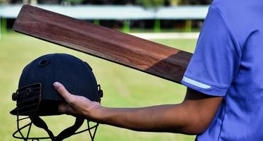 vecchio casco dello sport di cricket in mano, concetto per gli amanti del cricket di tutto il mondo. foto