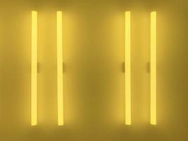 due tubi fluorescenti gialli su parete gialla. sfondo e concetto strutturato. foto