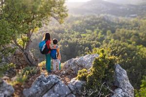 una donna viaggia con un bambino, un ragazzo con sua madre che guarda le montagne foto