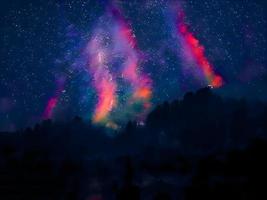 via lattea e luce rosa in montagna. paesaggio colorato notturno. cielo stellato con colline. bellissimo universo. sfondo dello spazio con la galassia. sfondo di viaggio foto