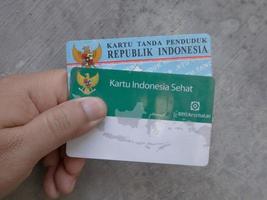 surabaya, jawa timur, indonesia, 2022 - un uomo con due carte sanitarie bpjs e un ktp indonesiano foto