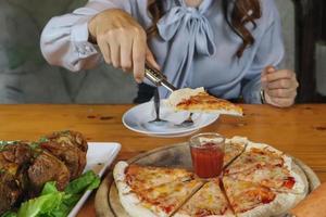 le pizze fatte in casa sono cotte nel forno a carbone e servite su vassoi di legno nel ristorante. pizza fatta in casa con ingredienti sani e farcire la pizza per far scegliere ai clienti. foto