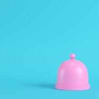 piatto rosa con cupola su fondo azzurro brillante in colori pastello foto