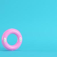 anello gonfiabile rosa su sfondo blu brillante in colori pastello foto