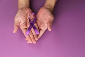 nastro viola come simbolo della giornata mondiale del cancro su sfondo di colore viola, spazio di copia. foto