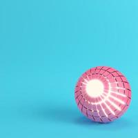 sfera rosa segmentata astratta che brilla all'interno su sfondo blu brillante in colore pastello foto
