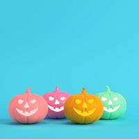 quattro colorate zucche di halloween, jack o lantern su sfondo blu brillante in colori pastello foto