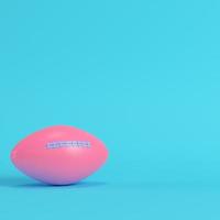 pallone da football americano rosa su sfondo blu brillante in colori pastello foto