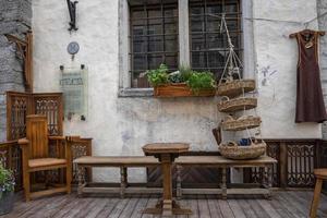 tavolo in legno disposto da panche e sedia con cesto appeso alla finestra foto