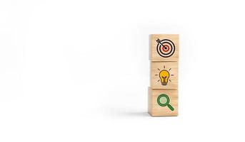 concetto di strategia aziendale e piano d'azione. blocco cubo di legno con icona target, lampadina e ricerca su sfondo bianco. foto