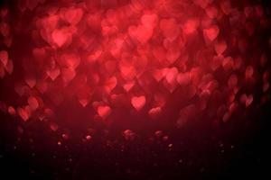 sfocatura rossa a forma di cuore di ligth bokeh su sfondo nero foto