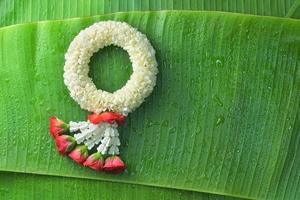 ghirlanda di gelsomino tradizionale tailandese. simbolo della festa della mamma in thailandia su foglia di banana foto