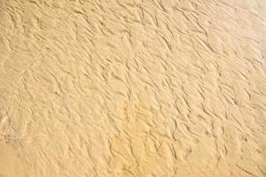 fondo di struttura marrone della spiaggia di superficie della sabbia di mare. vista dall'alto foto