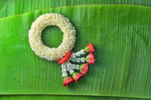 ghirlanda di gelsomino tradizionale tailandese. simbolo della festa della mamma in thailandia su foglia di banana foto