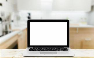 computer moderno, laptop con schermo vuoto su tavolo in legno su sfondo sfocato cucina foto