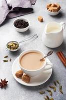 bevanda indiana tè masala con latte e spezie. bastoncini di cardamomo cannella anice stellato zucchero di canna. foto