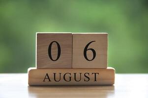 testo della data del calendario del 6 agosto su blocchi di legno con parco di sfondo sfocato. copia spazio e concetto di calendario foto