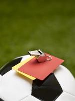 fischietto, cartellini rossi e gialli su un pallone da calcio foto