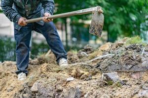 il giardiniere scava il terreno con la sua attrezzatura per il giardinaggio e prepara il terreno per la piantagione. foto