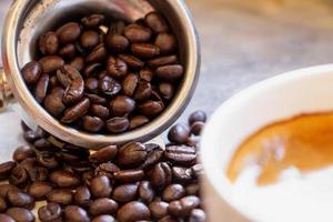 primo piano del cestello portafiltro con chicchi di caffè arabica tostati marrone scuro organici all'interno. foto