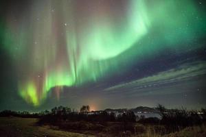 composizione oraria di aurora boreale sul mare foto