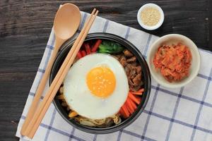 bibimbap, insalata piccante coreana con riso e uovo fritto in stile tradizionale coreano foto