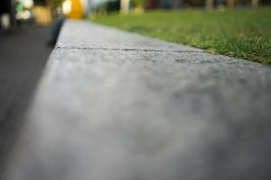 primo piano e macro passo di pietra piatto accanto al campo in erba per lo sfondo. foto