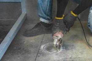 l'operaio edile sta tagliando il pavimento con una macchina a lama media per mantenere la forma circolare con molta polvere attorno per installare l'armadio con. foto