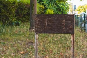 un cartello di legno vuoto in un parco cittadino foto