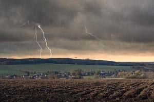 un campo in autunno con un temporale foto