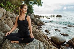 donne che fanno yoga con l'oceano dietro foto