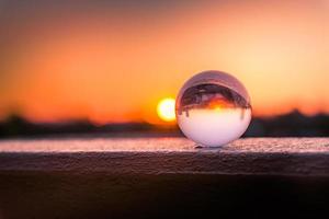 una palla di vetro in un tramonto rosso in natura foto