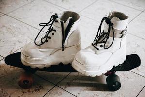 scarpe bianche su uno skateboard foto