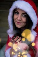 una donna di Natale con una catena di luci in mano foto