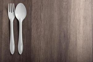 cucchiaio e forchetta bianchi su sfondo grigio foto