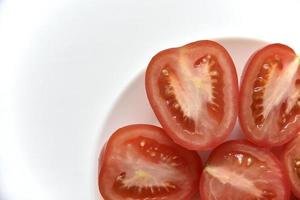 pomodoro rosso affettato su un piatto bianco foto